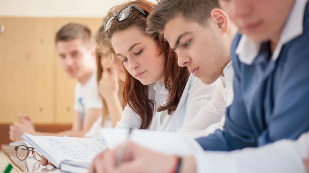 A group of students reading books in a classroom