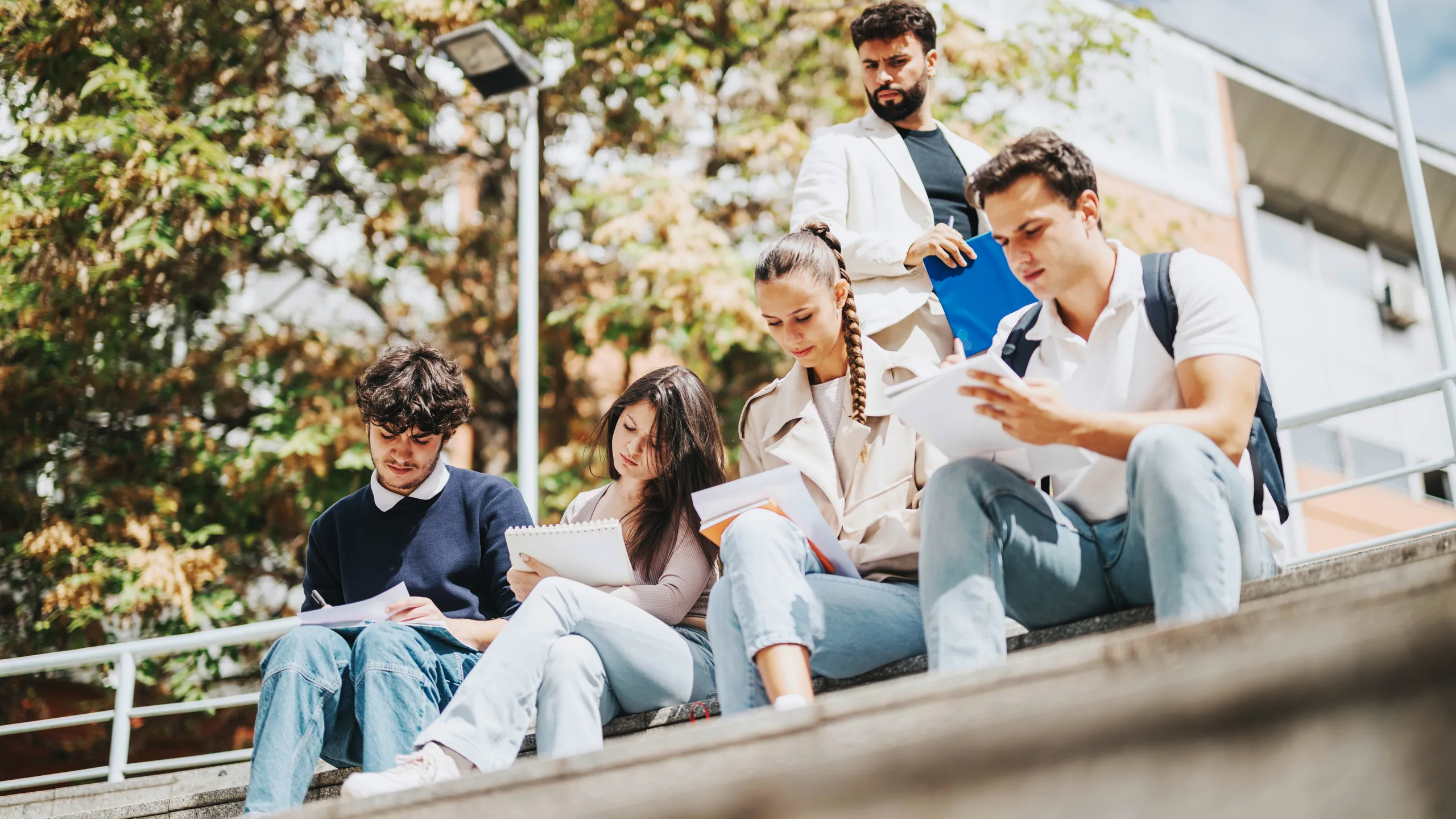 High school students working outdoors with professor assistance