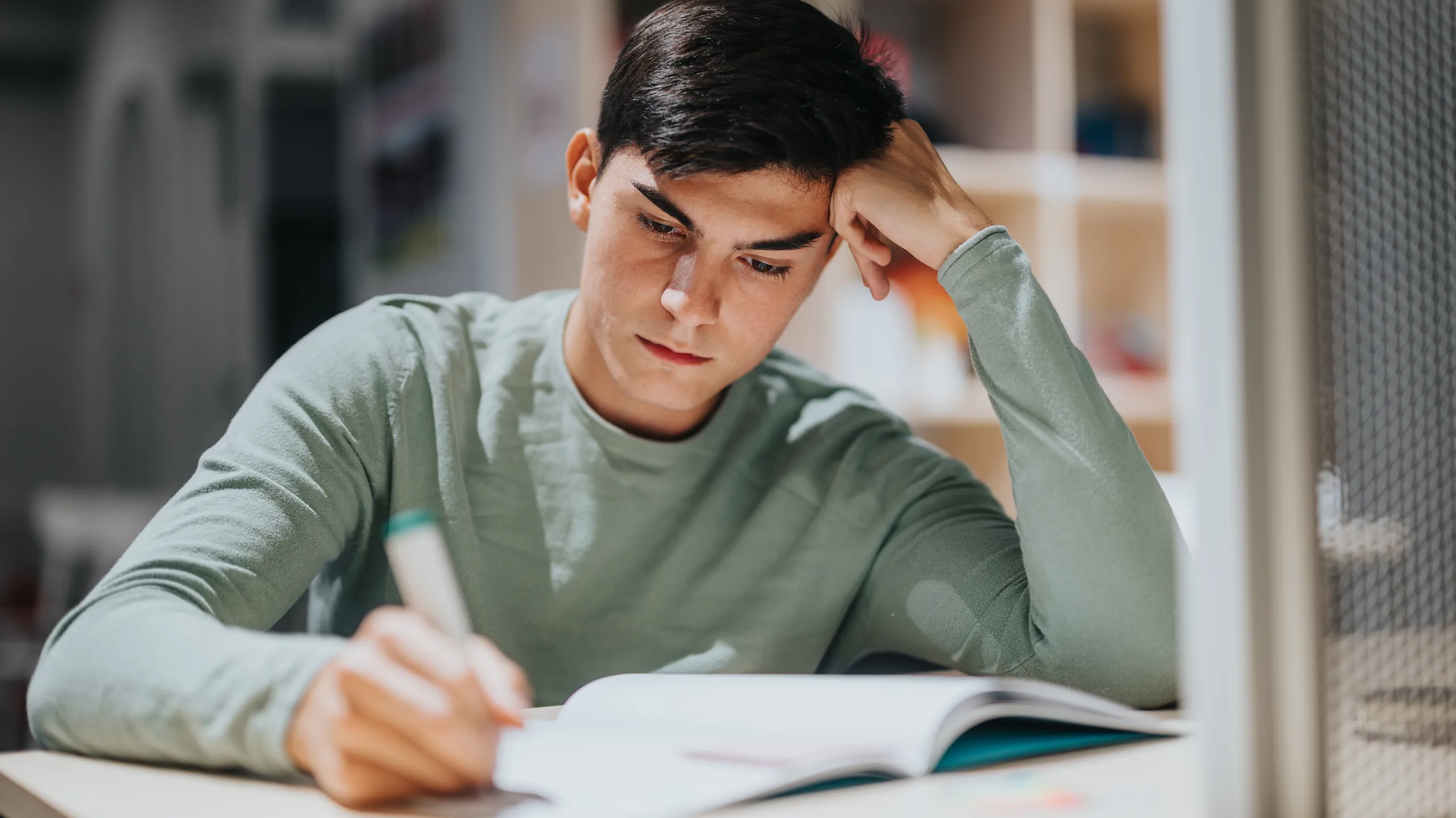 Focused high school student studying diligently in classroom setting