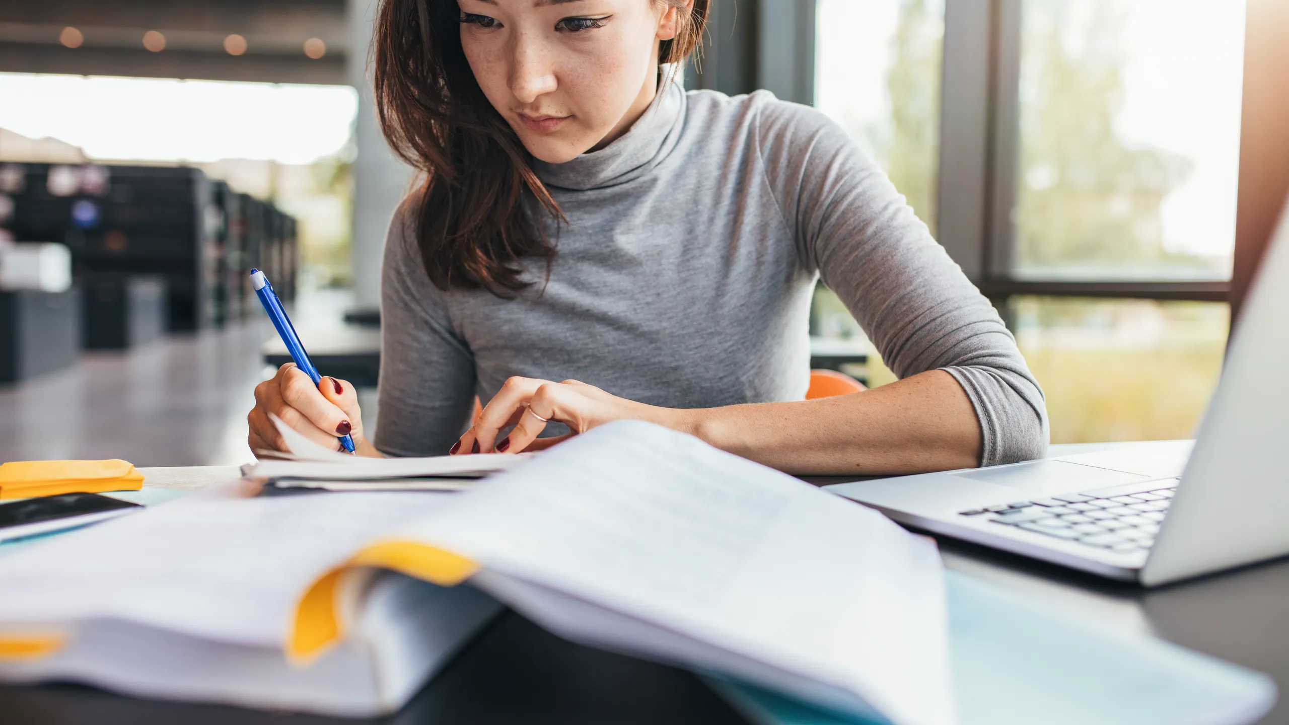 Student taking notes from textbook