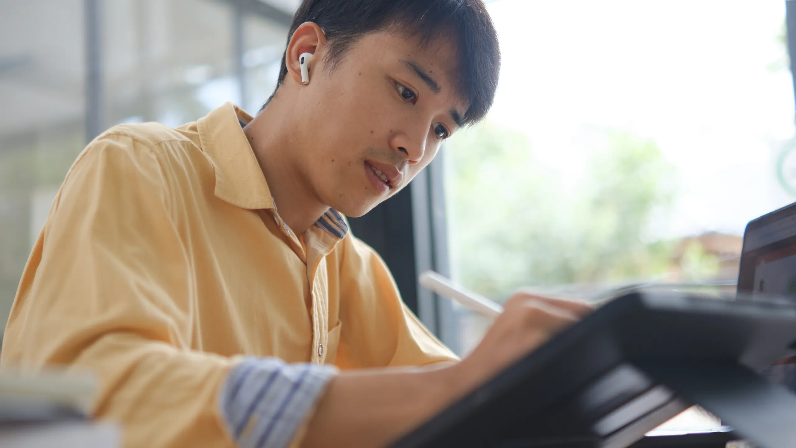 Student studying online and preparing for exams with digital devices and books