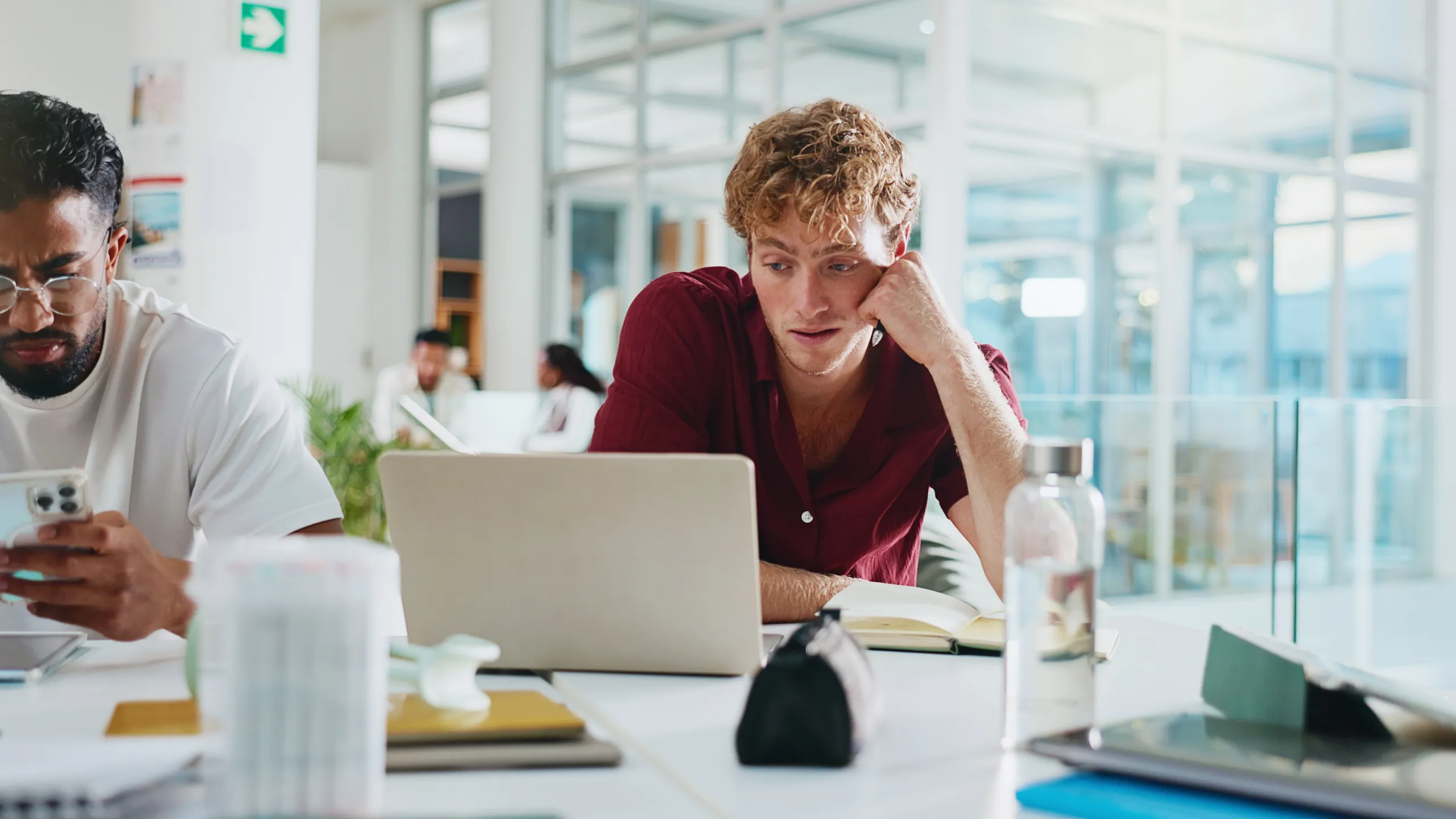 Student, laptop and bored with learning at college for exam study, low energy or education fatigue. University, man or technology on campus with assignment burnout, essay research or difficult course