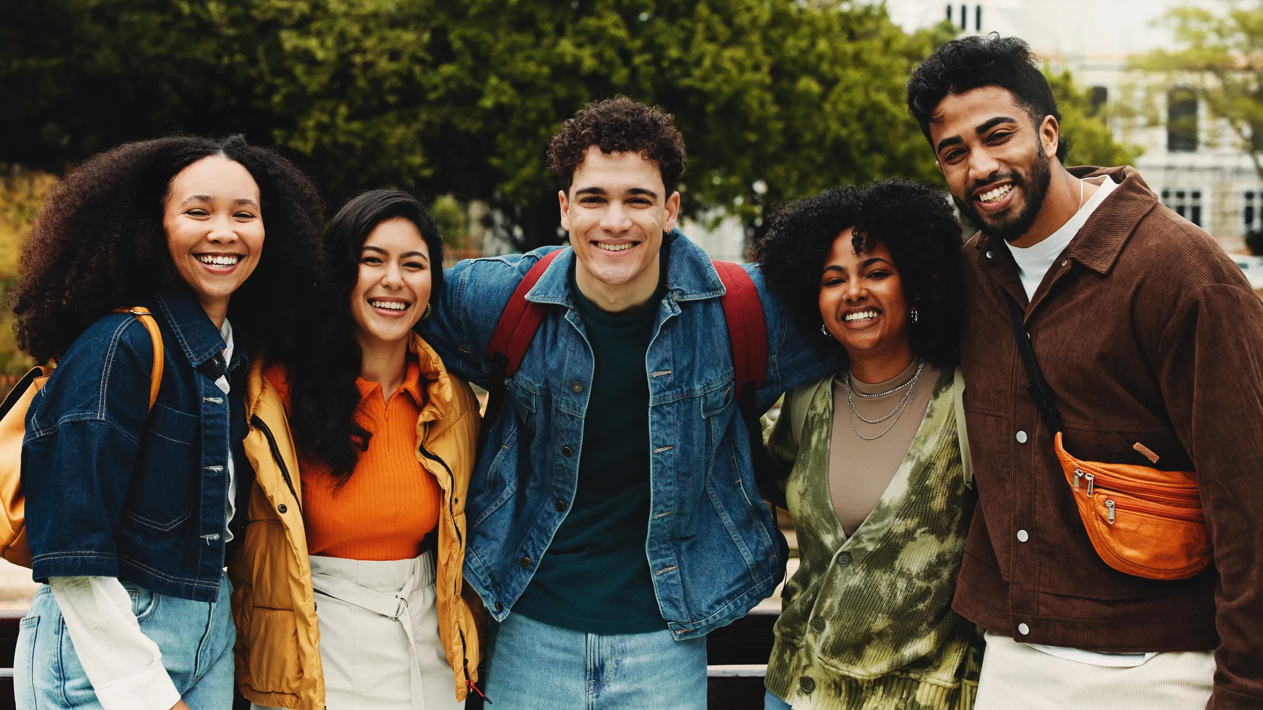 Portrait, friends and students with hug on campus, education support and outdoor bonding on study break. University scholarship, connection or happy people embrace together, care or knowledge outside