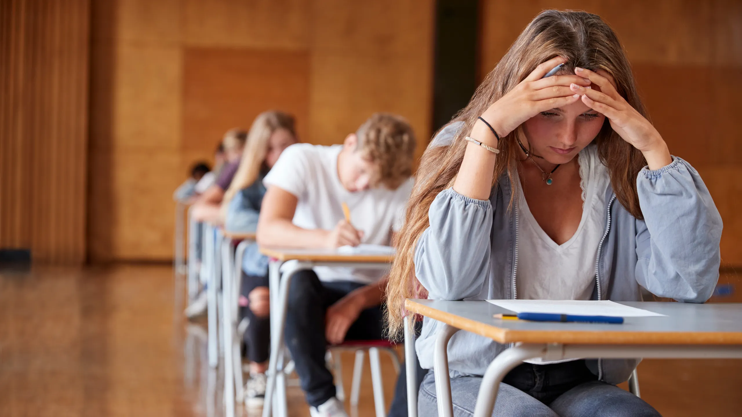 Anxious Teenage Student Sitting Examination In School Hall