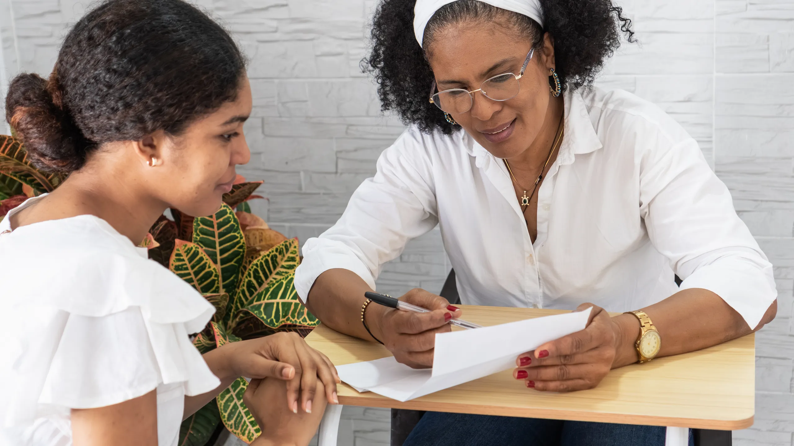 Mentor guiding student reviewing university acceptance letter