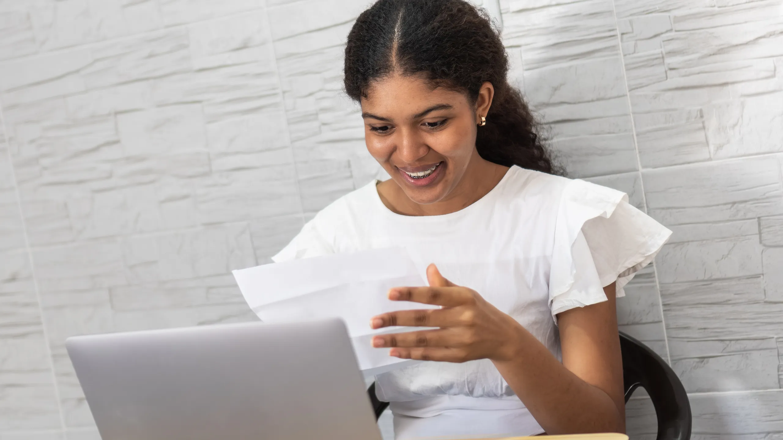 Young woman receiving university acceptance letter with excitement