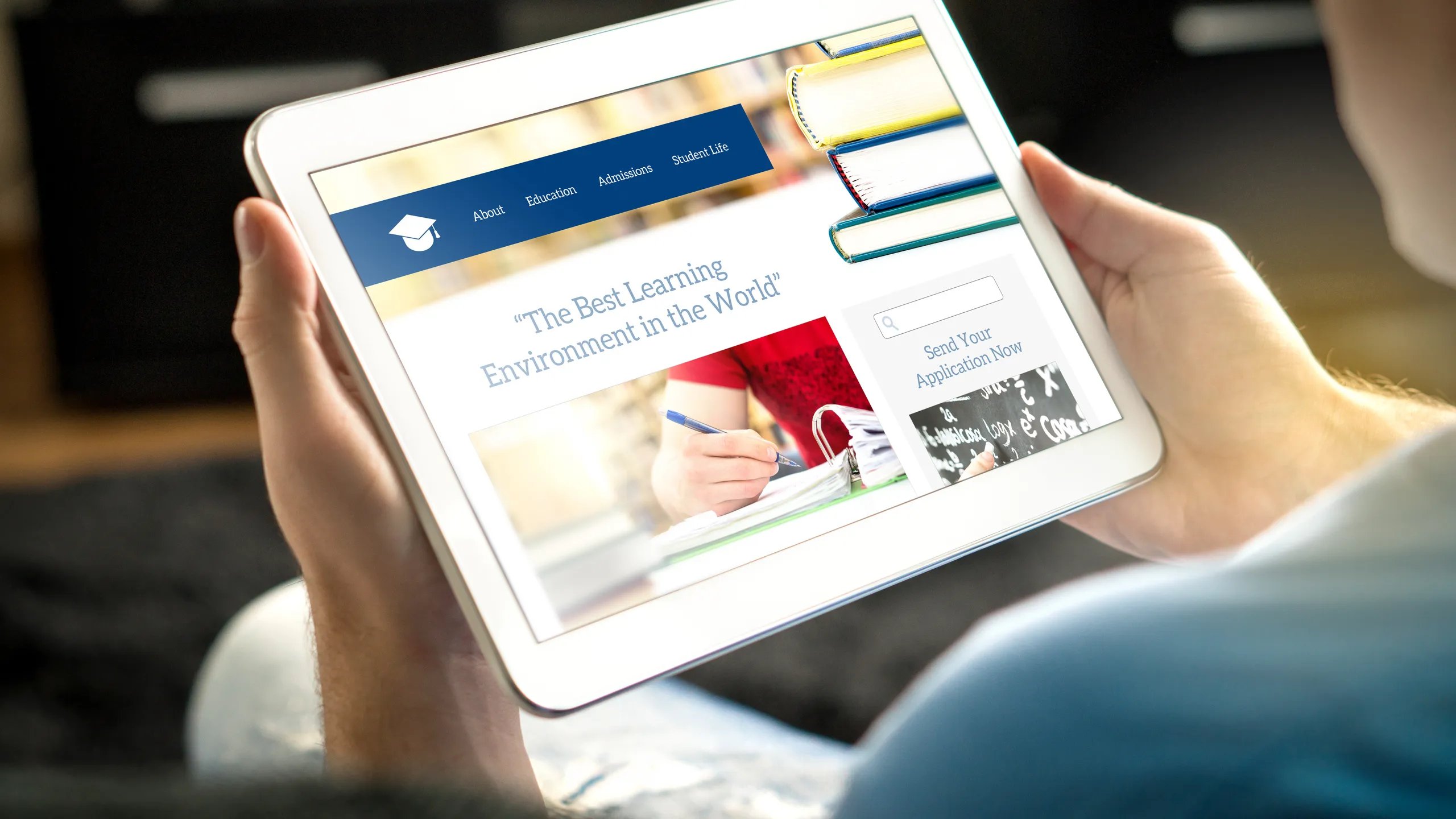 School website on tablet screen. Young man and applicant browsing college or university websites before applying. Searching information about education and institutions.