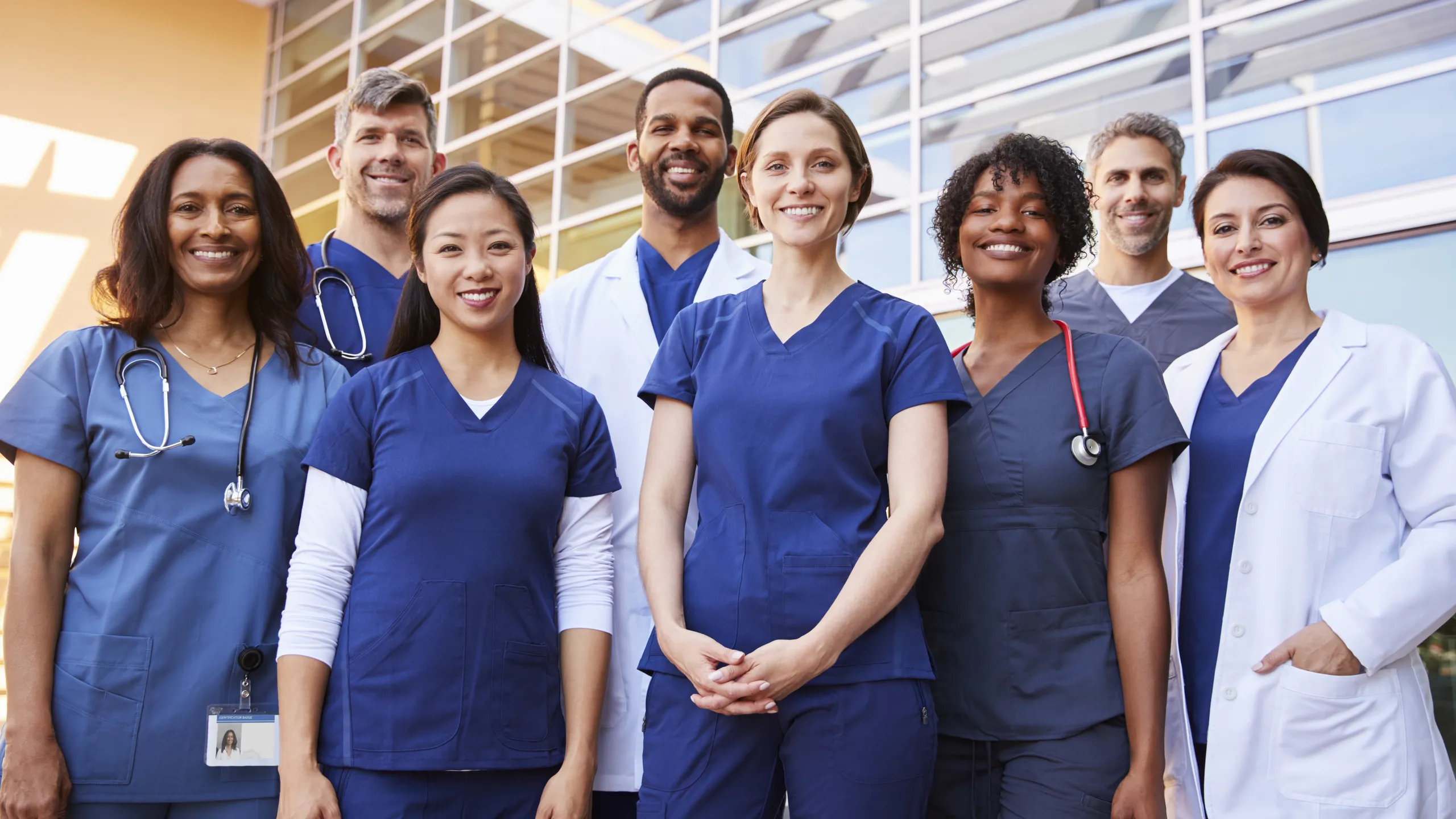 Smiling medical team standing together outside a hospital