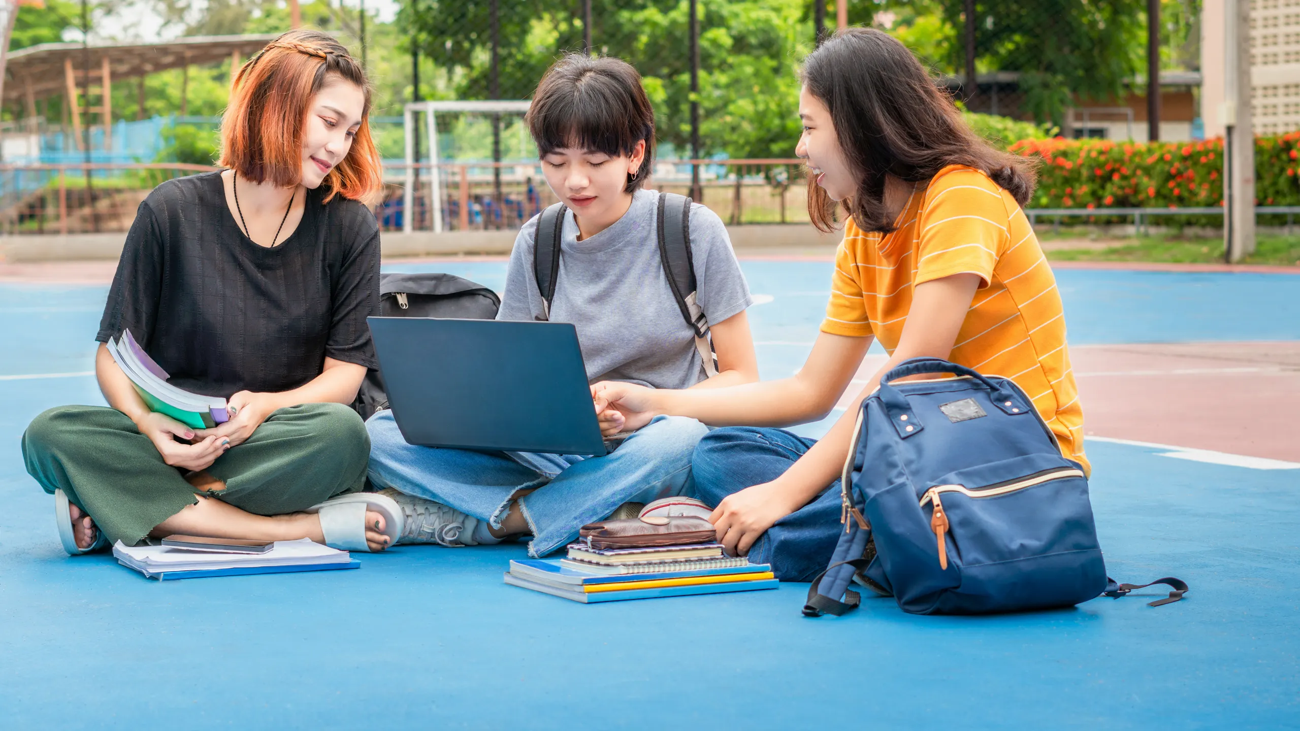 Students young asian together reading book study smiling with tablet,laptop computer at university high school campus.