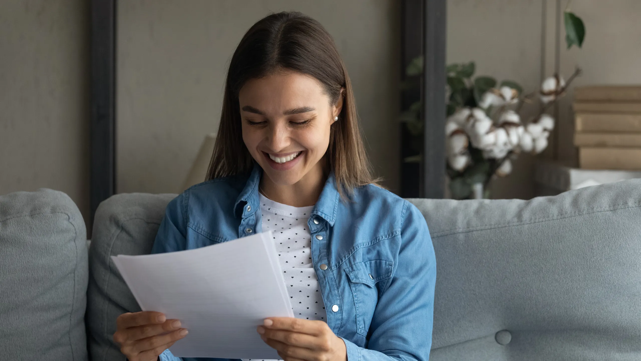 Close up smiling woman reading good news in letter