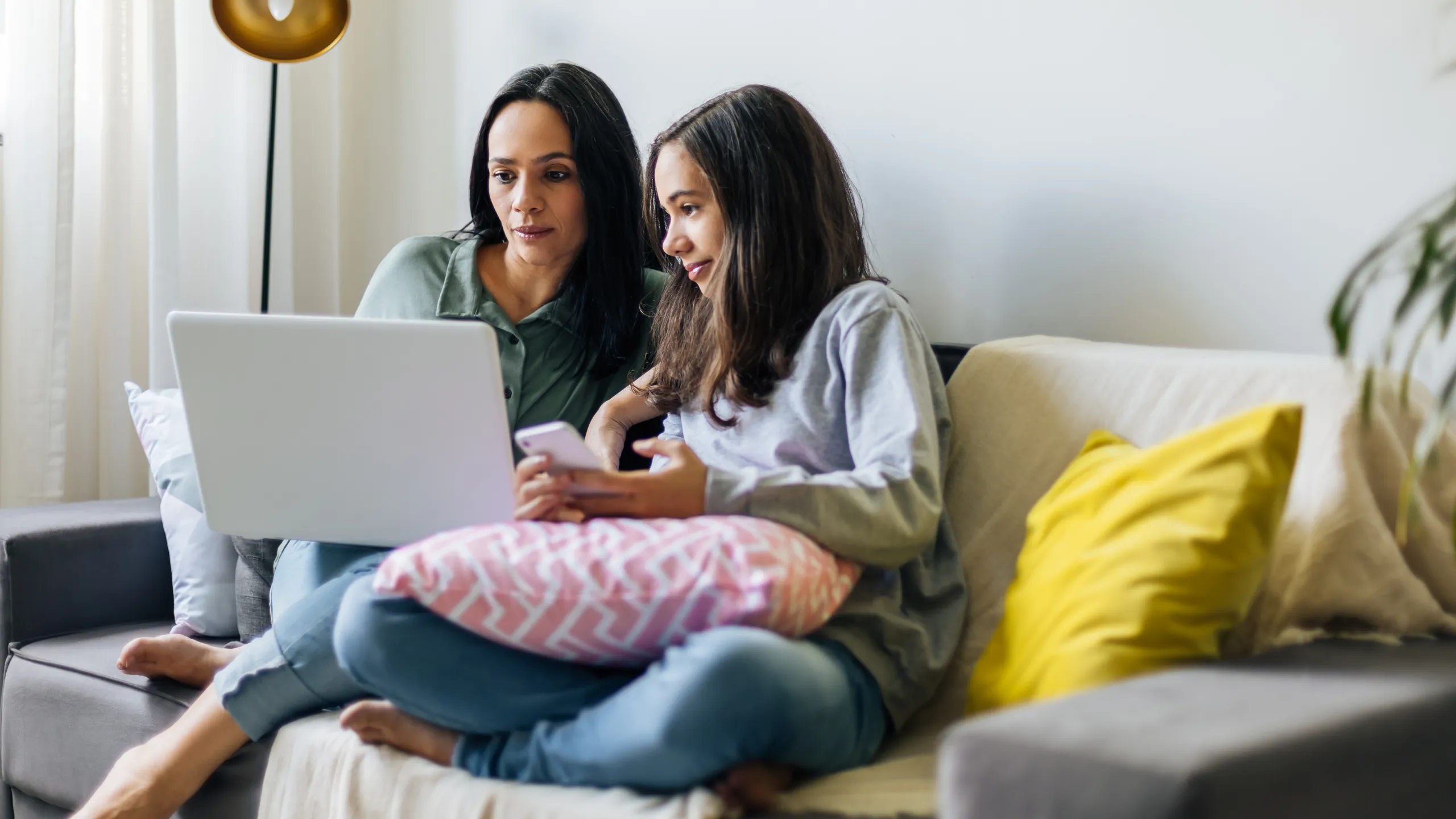 Single mother working from home with preteen daughter around