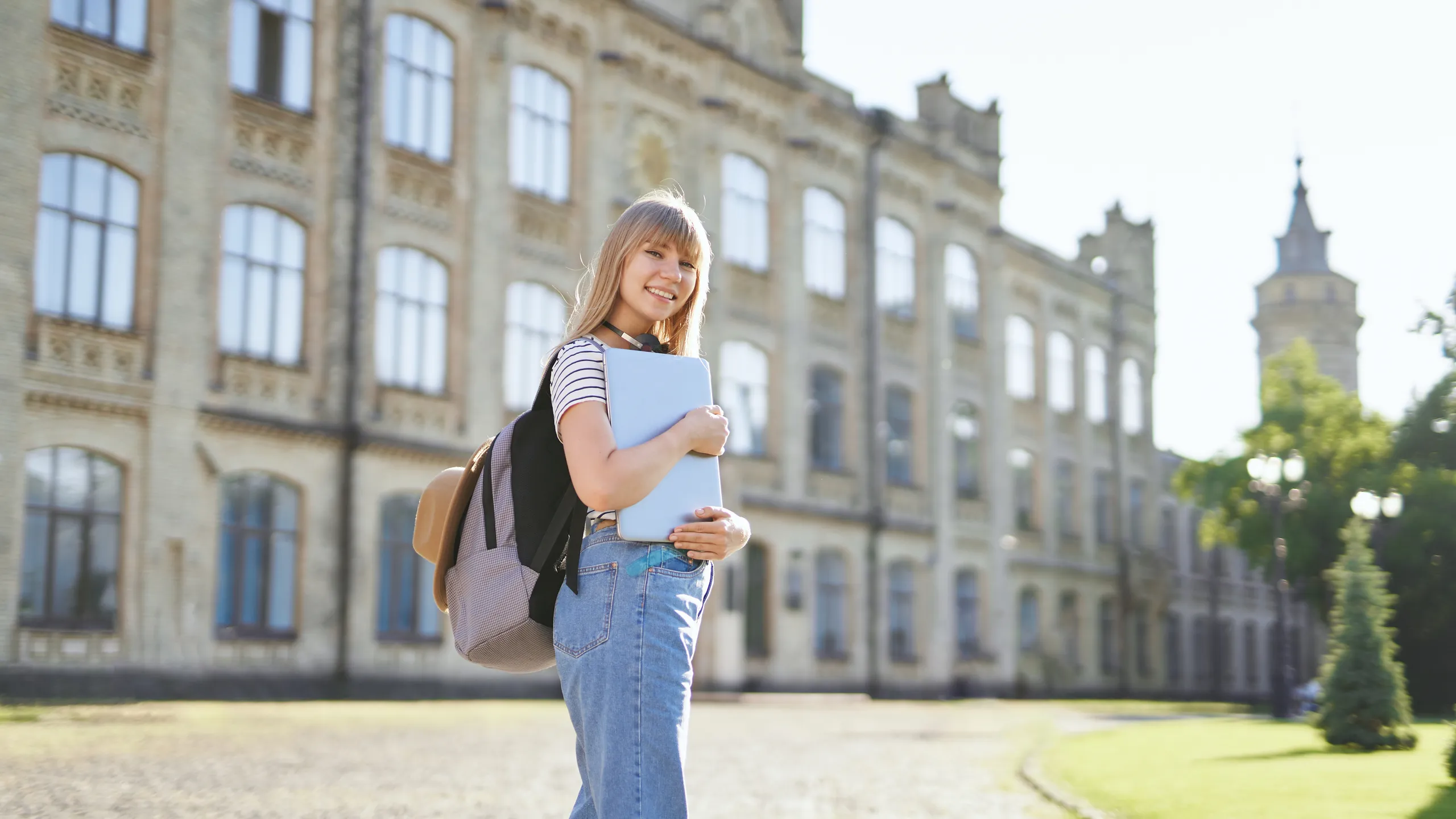 University blonde student girl outdoor at campus with laptop