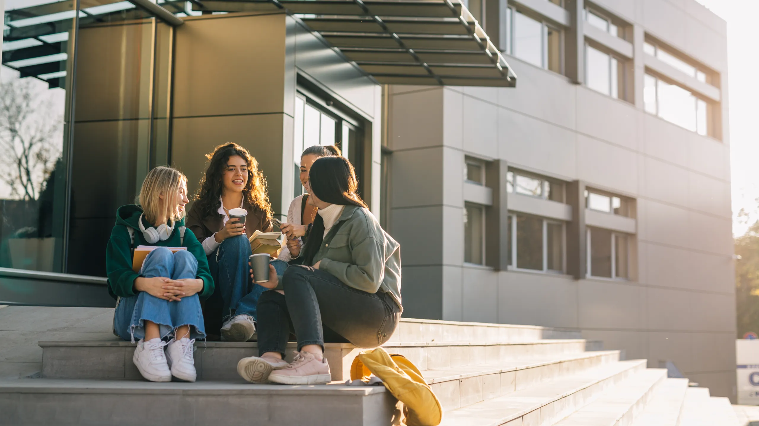 group of female college students outdoor in campus talking and smiling