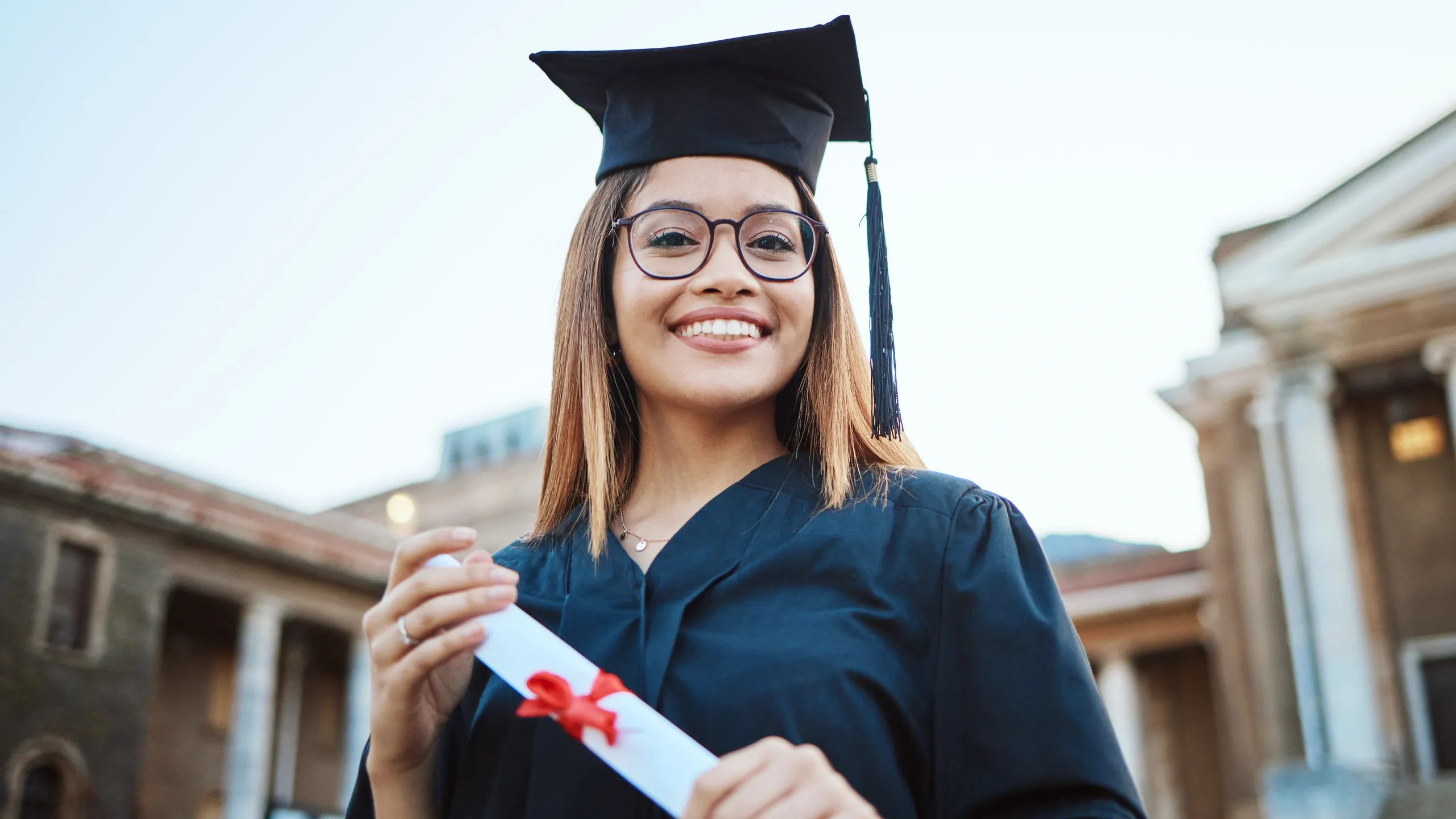 Portrait, graduate and study with a student woman holding a diploma or certificate outdoor on graduation day. Education, goal or unviersity with a female pupil outside after scholarship success