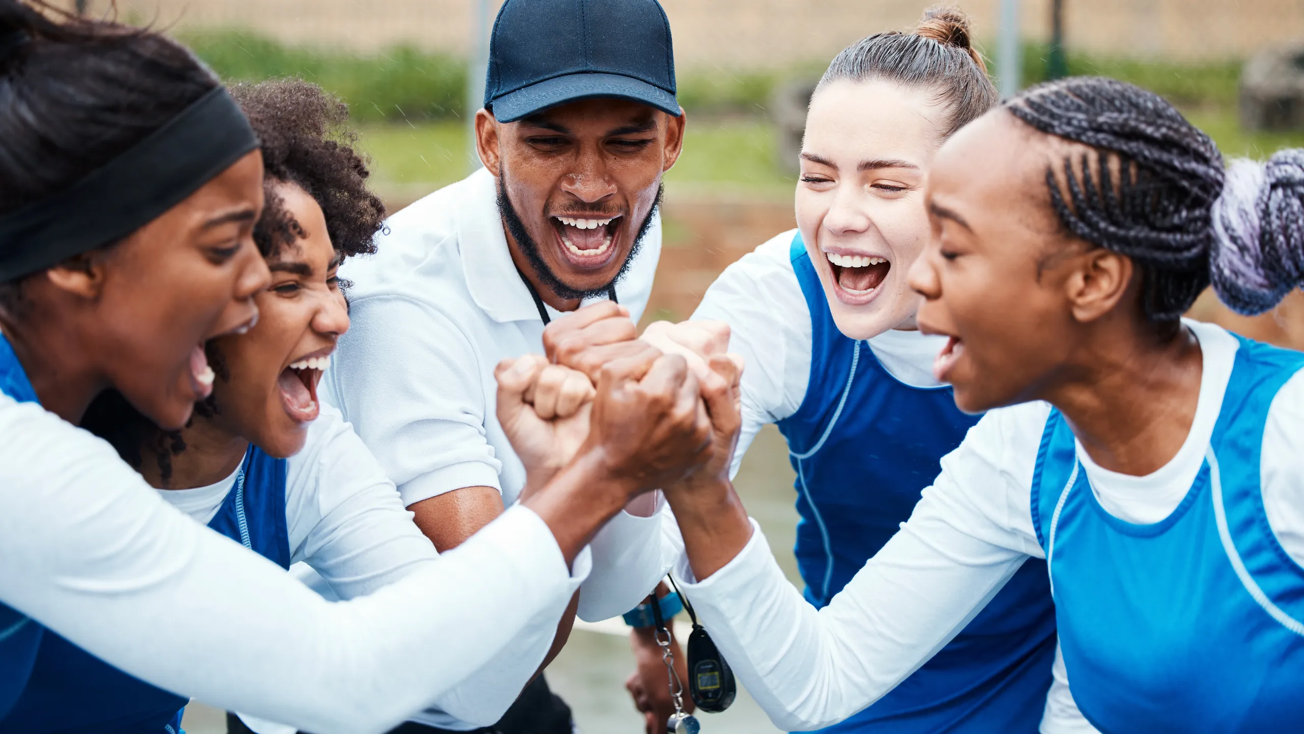 Fist, motivation or team support in netball training game screaming with hope or faith on sports court. Teamwork, fitness coach or group of excited athlete girls with pride or solidarity together