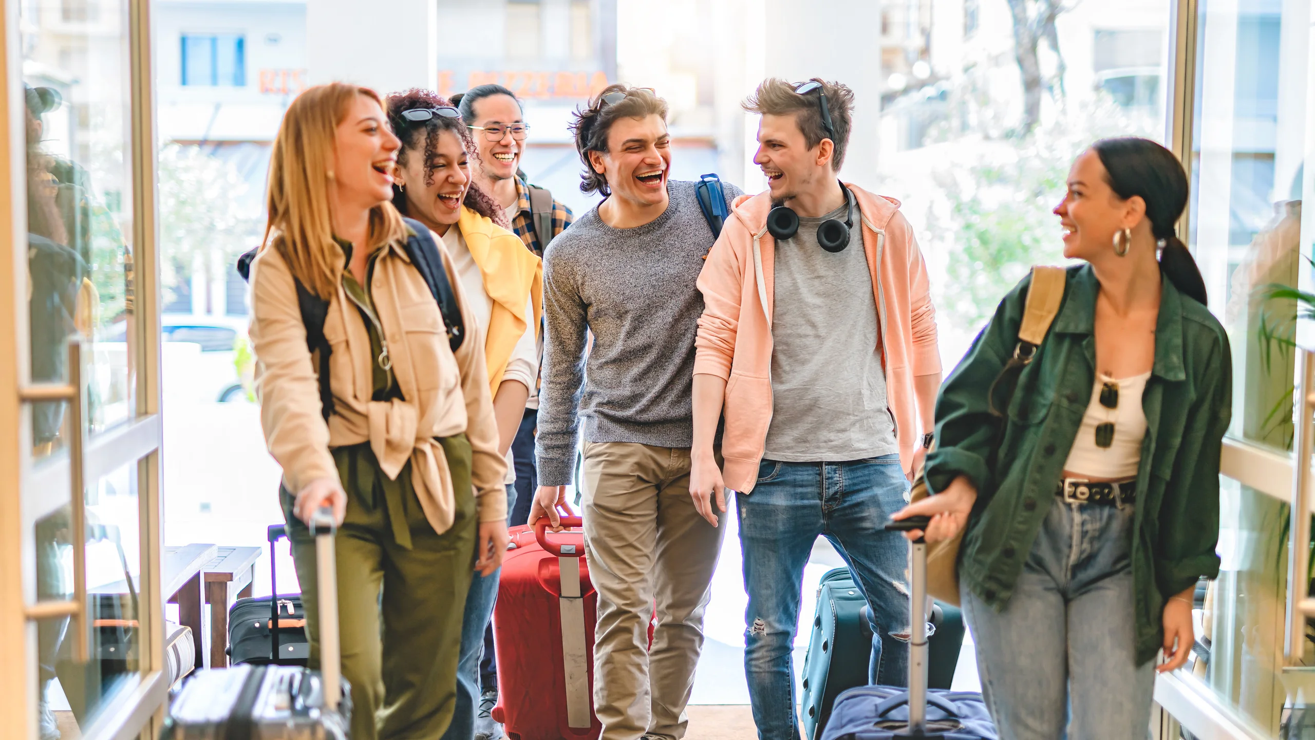 Group of university college tourist walking inside the hotel with suitcases -Young happy students enjoying summer holiday-Tourism Vacation and Lifestyle concept with people-Youth culture-Spring time
