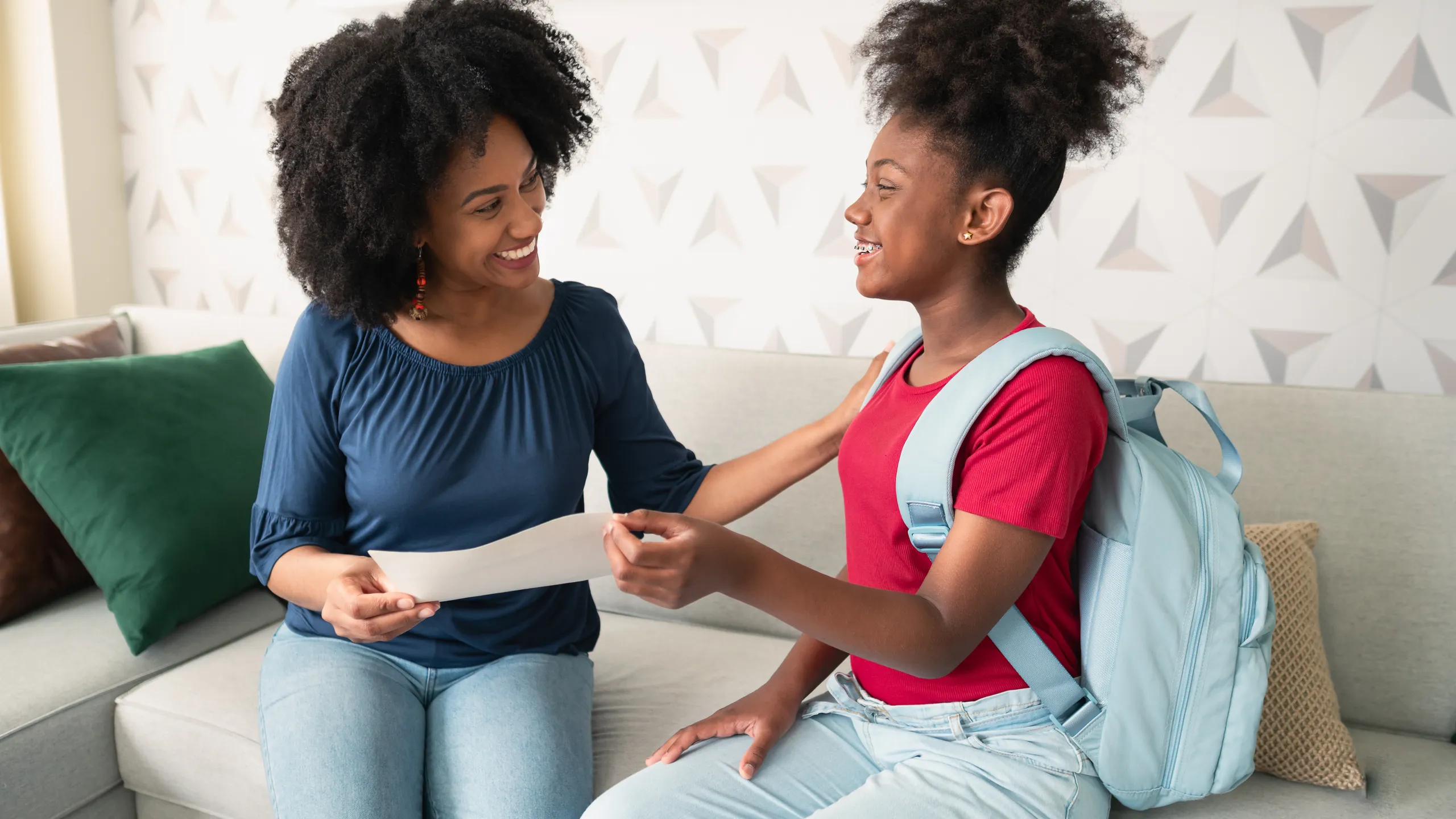 Daughter delivers school report card to mother in living room