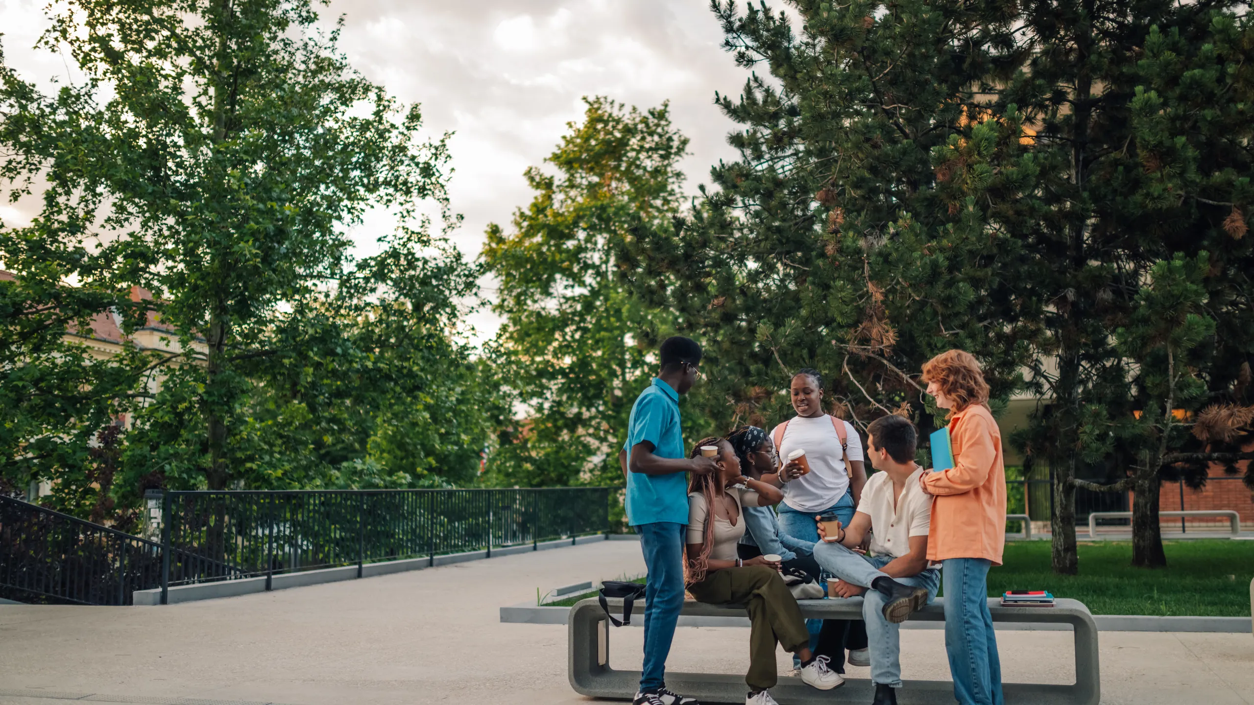Full length of diverse students on coffee break talking at college campus