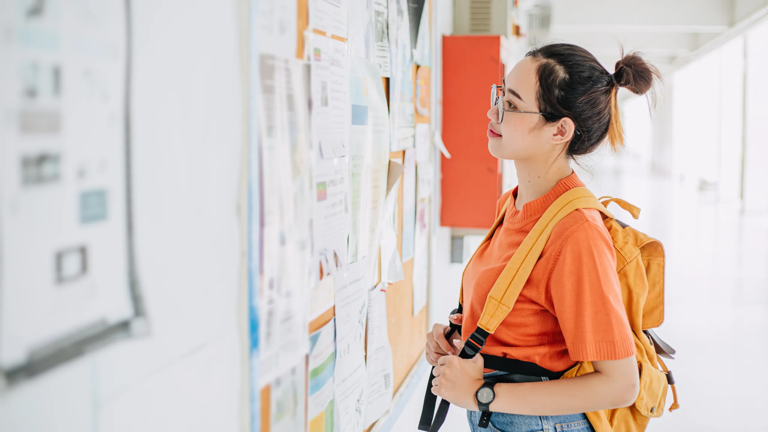 Asian university student girl looking, find search for a part time jobs, teen working during free time post announce at campus advertising billboard