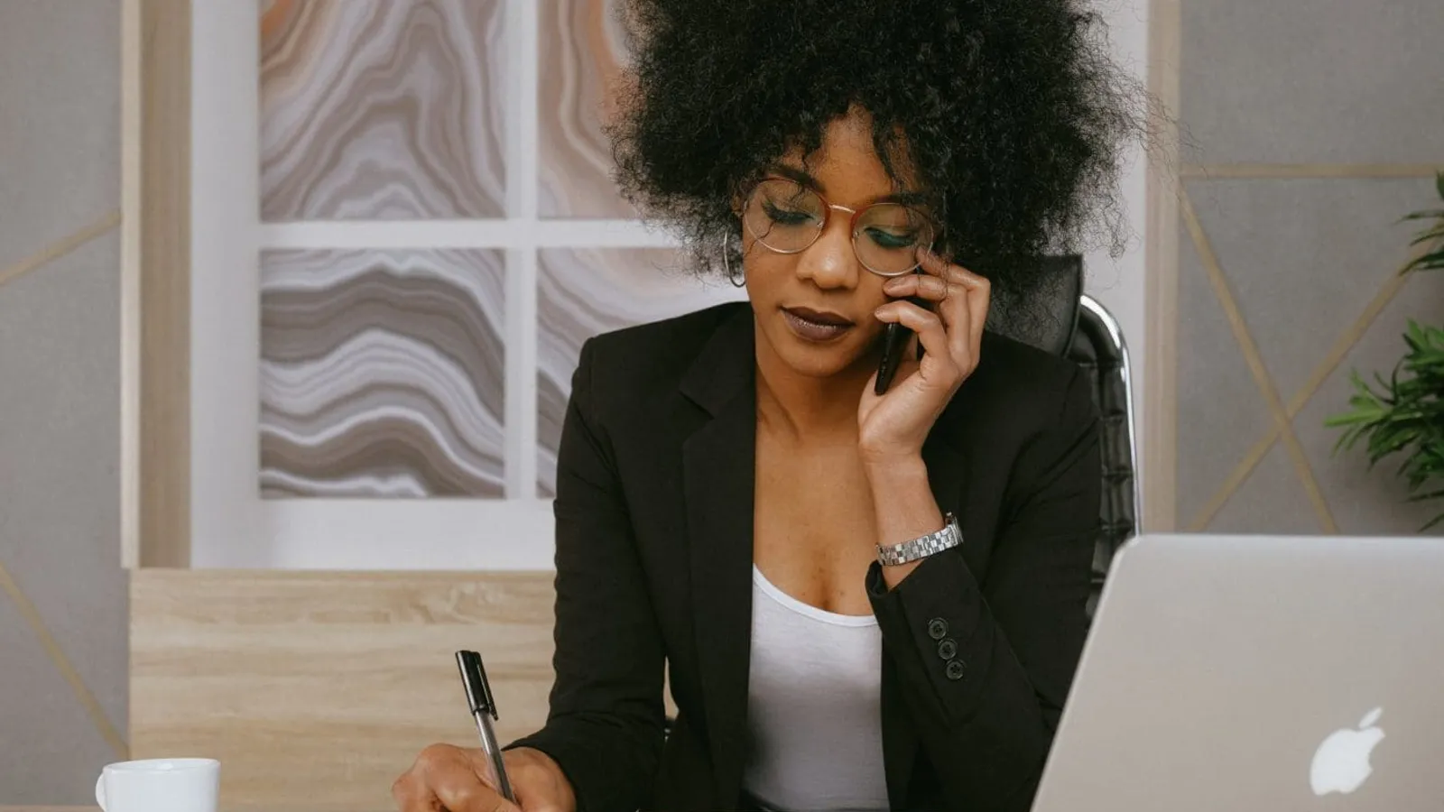 woman in black blazer holding smartphone