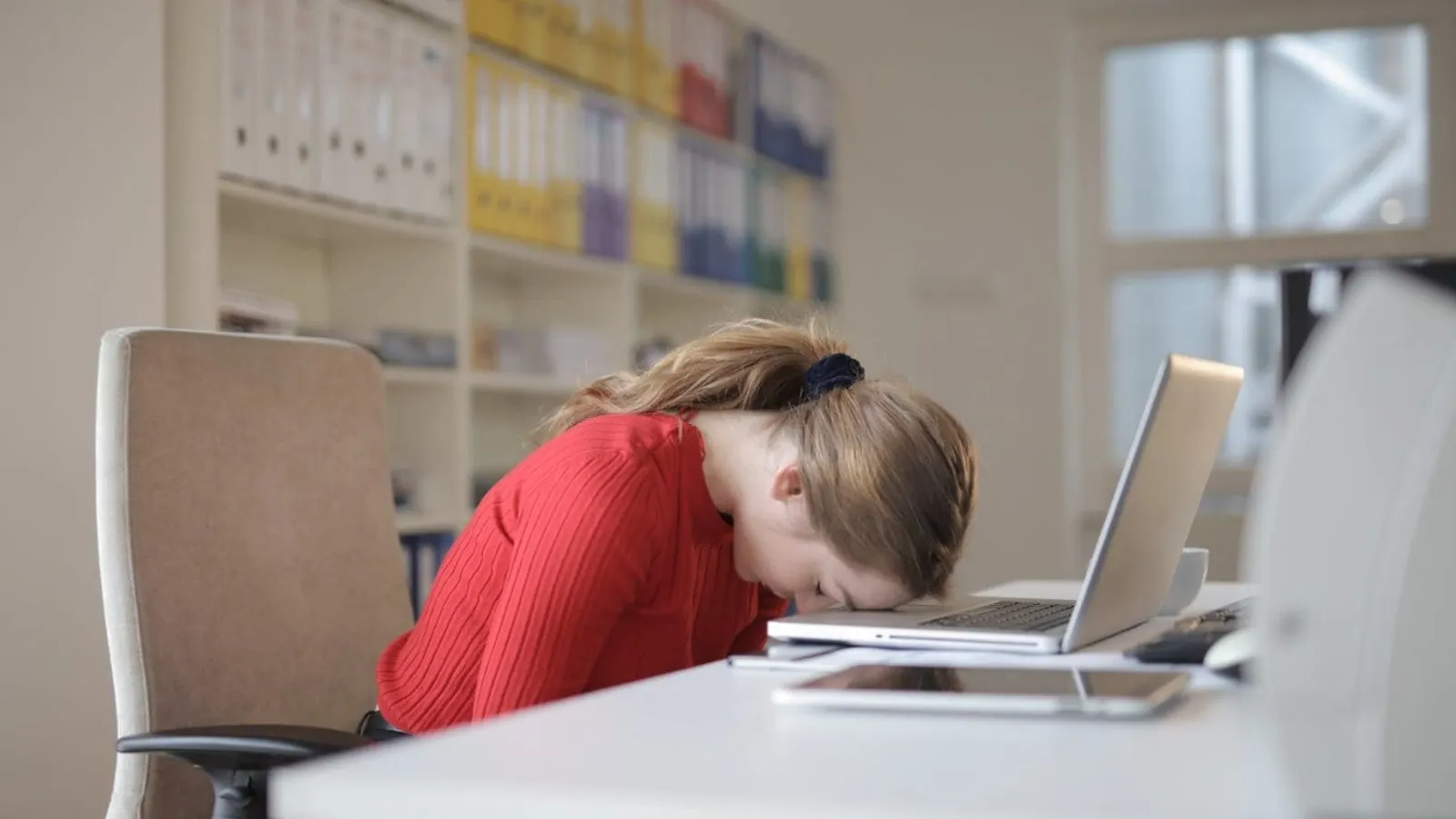 woman sitting on chair while leaning on laptop