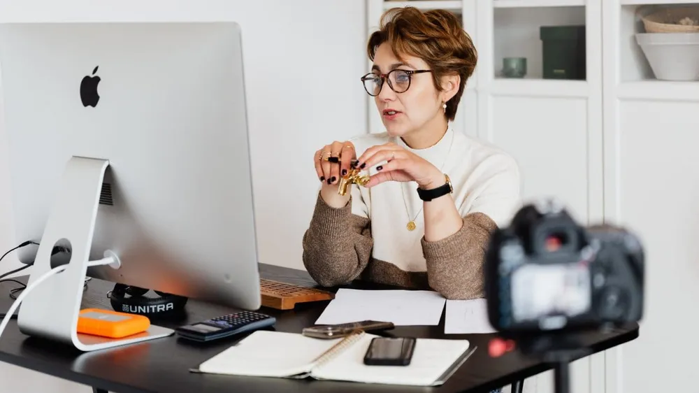 confident elegant lady in eyeglasses hosting webinar