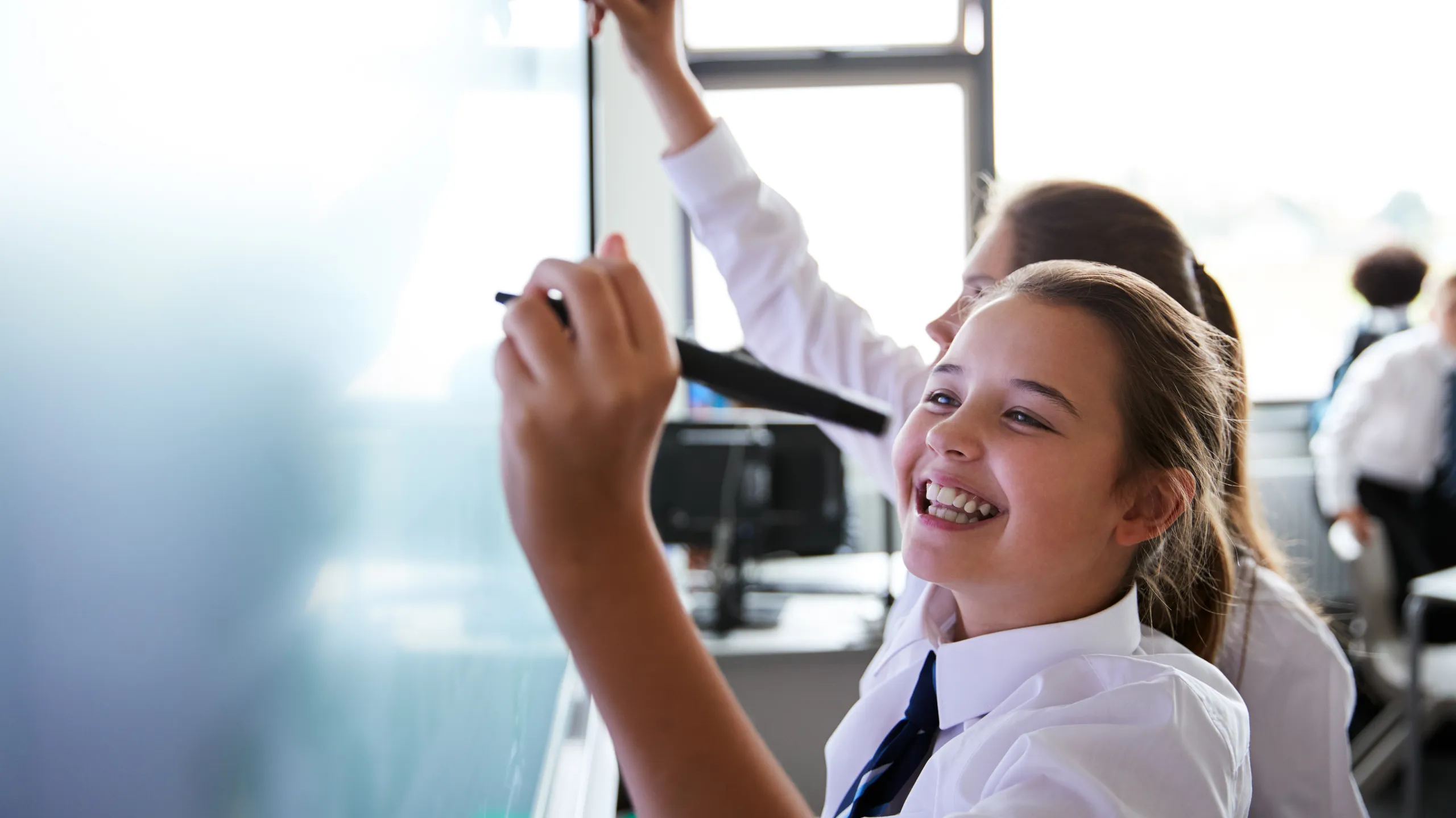 young students writing on chalkboard