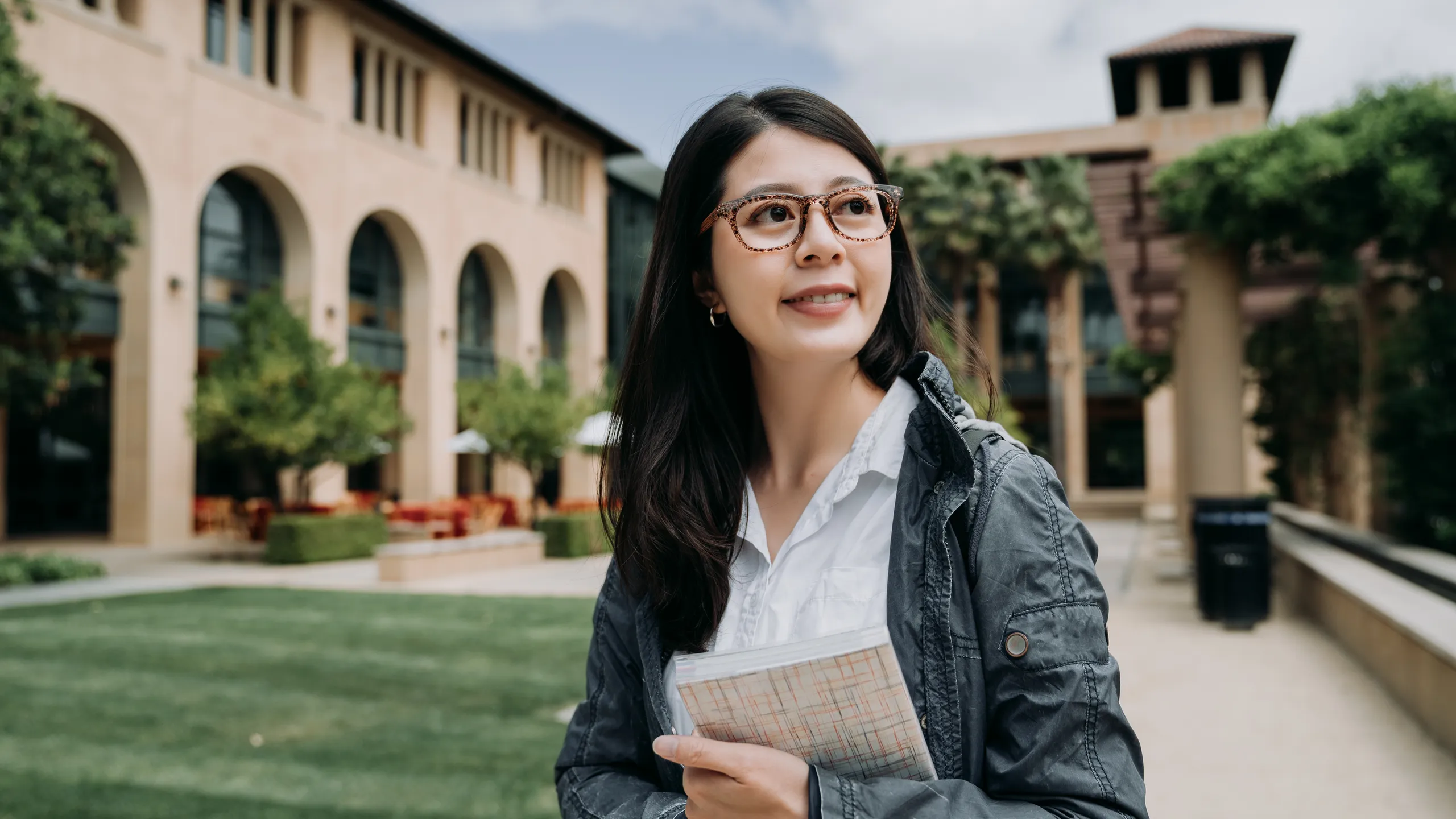student holding a book on campus
