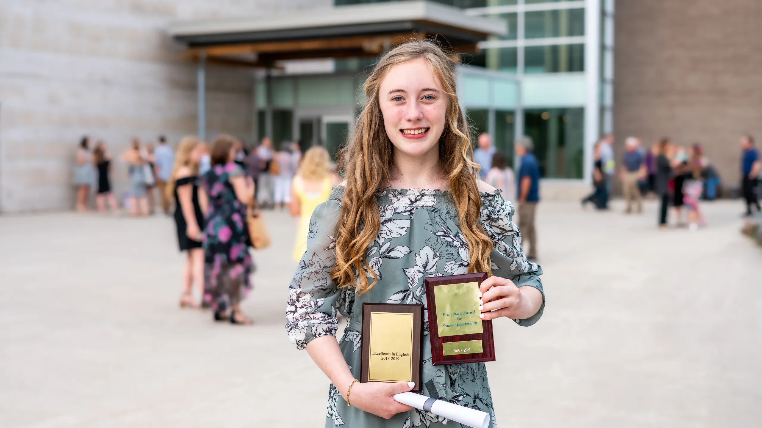 student holding eighth grade graduation award