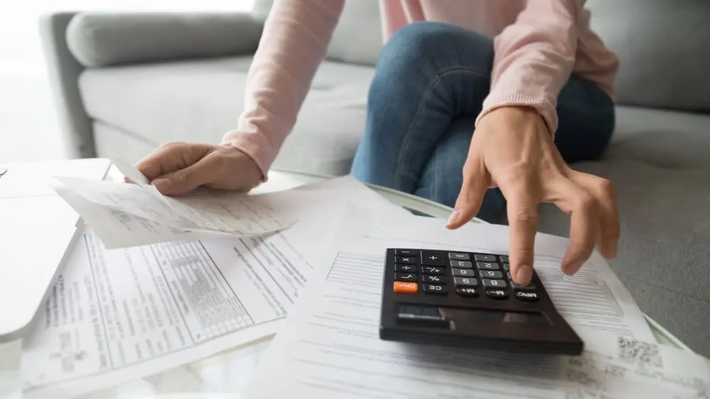 student calculating bills using calculator