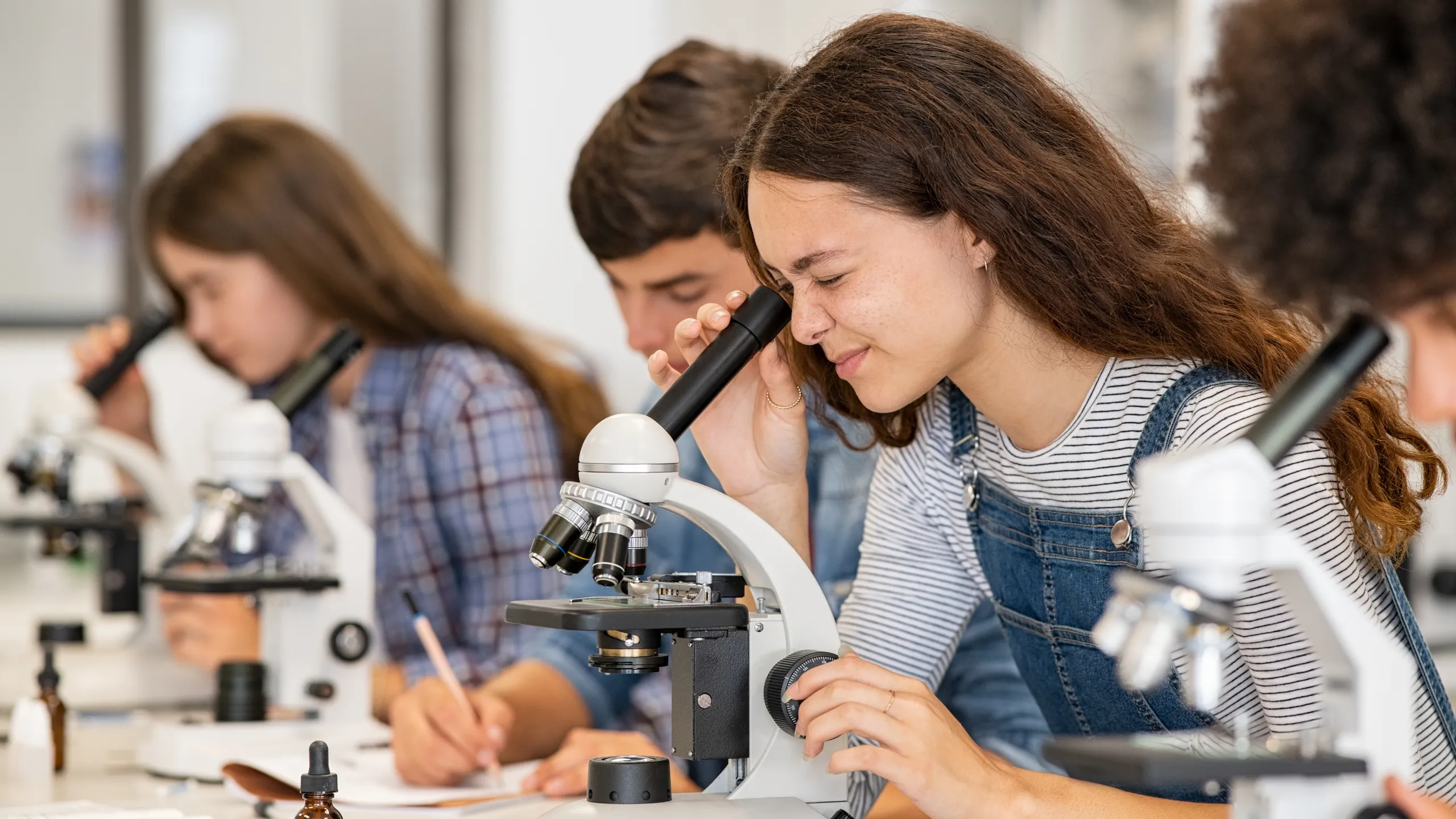 student looking in microscope