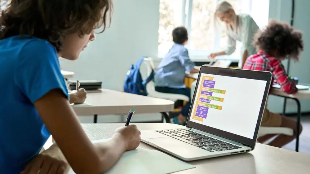 middle school student using laptop in class