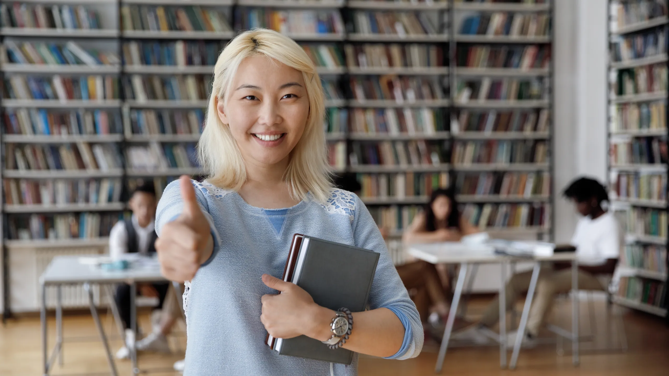 student holding books at the library