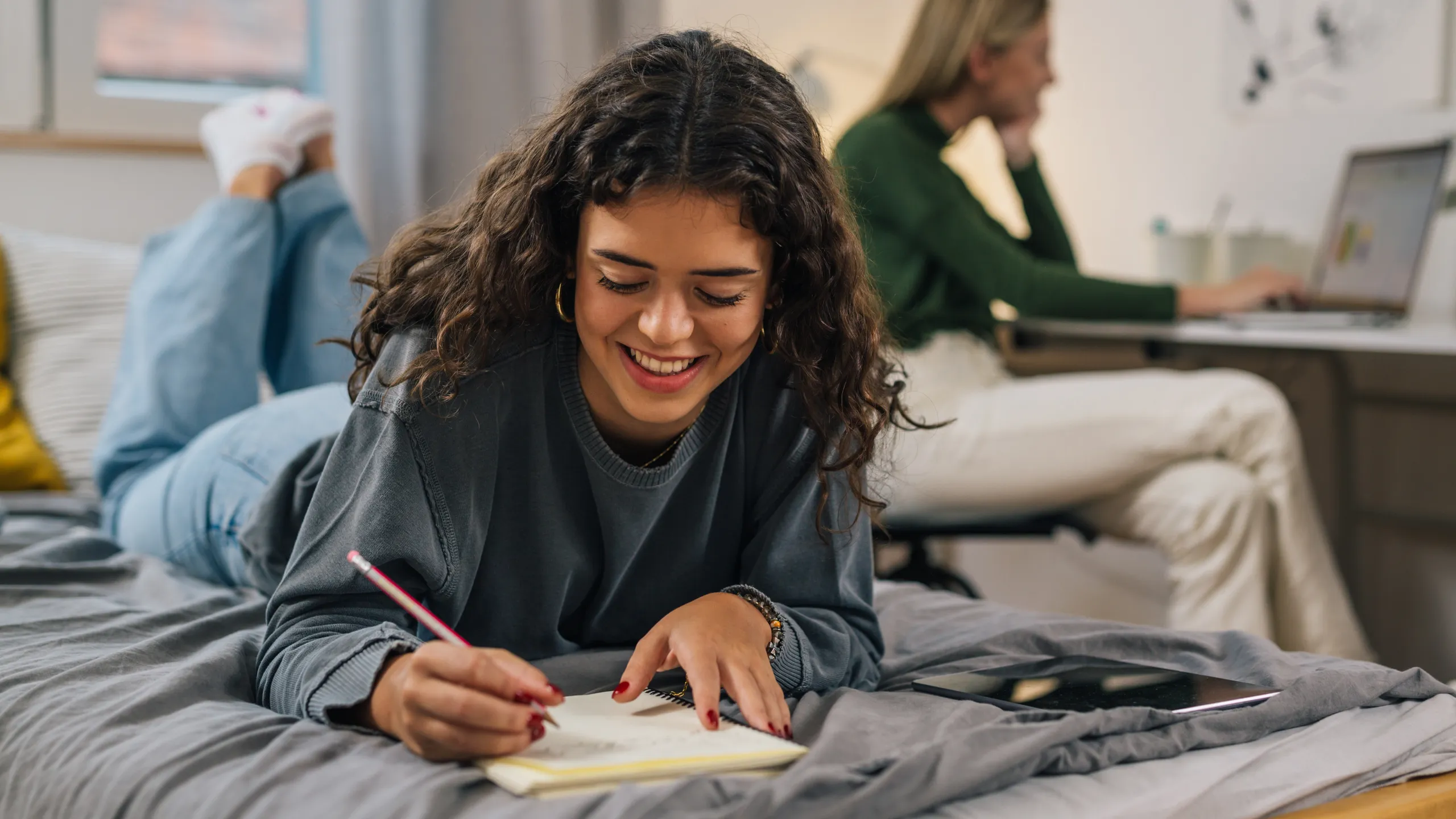 student doing homework on bed