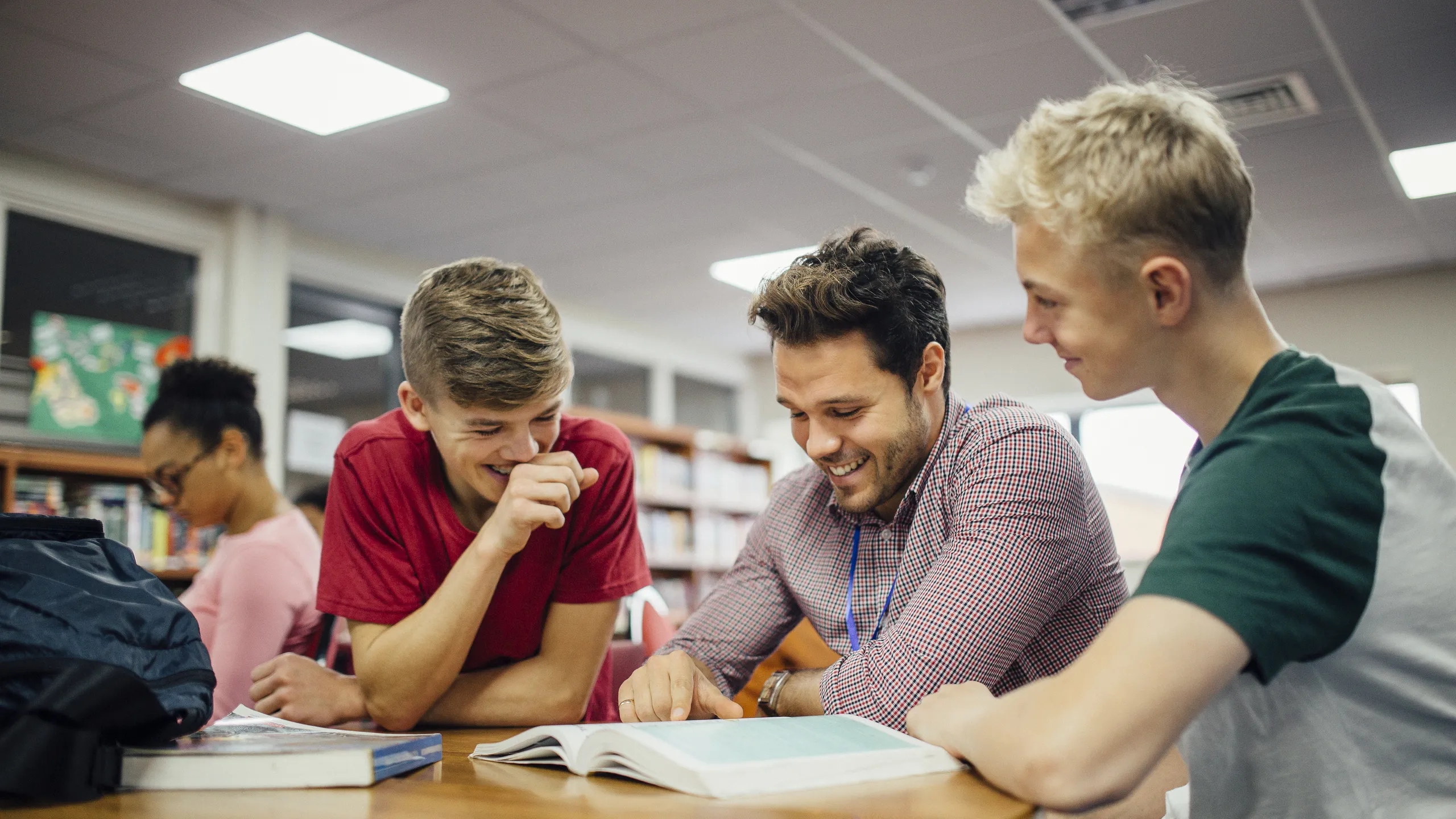 student engaging with their teacher at the library